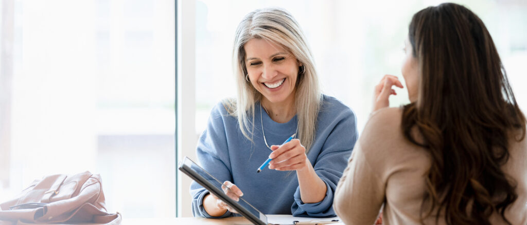 woman going over documents on a tablet with a client